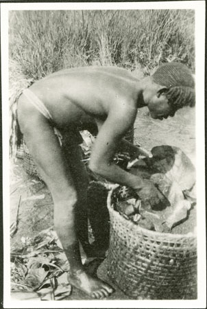 Zande woman preparing grain for beer