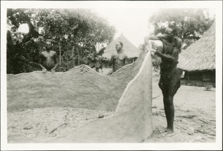 Building clay wall of Zande hut