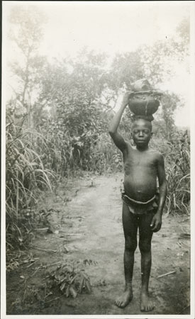 Zande boy bringing food for a chief