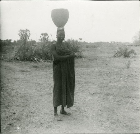 Mandari woman carrying pot on head