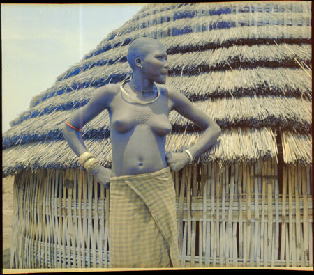 Mandari woman in front of hut