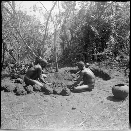 Mandari men digging clay for pot-making