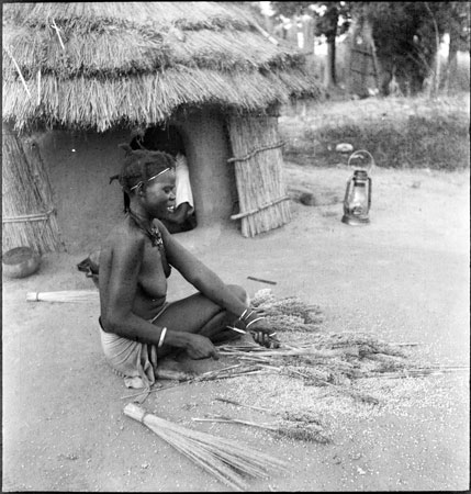 Anuak woman threshing millet