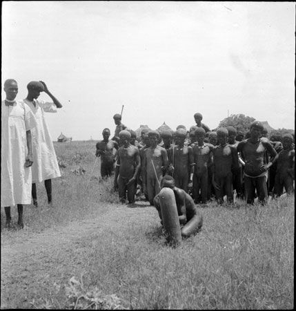 Dinka youths kneeling on path