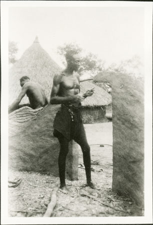 Building clay wall of Zande hut