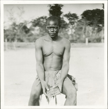 Zande man playing kundi instrument