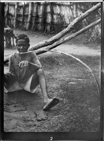 Zande boy playing monochord instrument