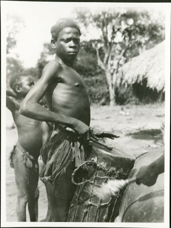 Zande youth playing drum