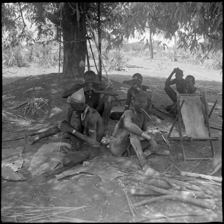 Mandari men socialising in tree shade