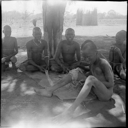 Mandari youths making bead strings