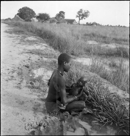 Dinka mother washing child