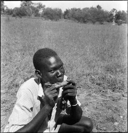 Dinka youth playing mouth organ