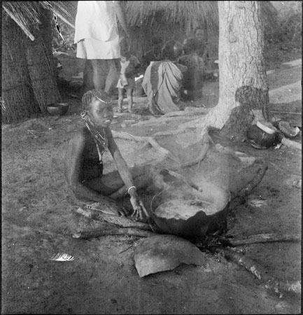 ?Dinka girl preparing food