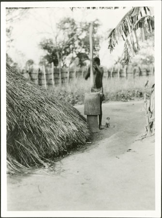 Zande girl with mortar